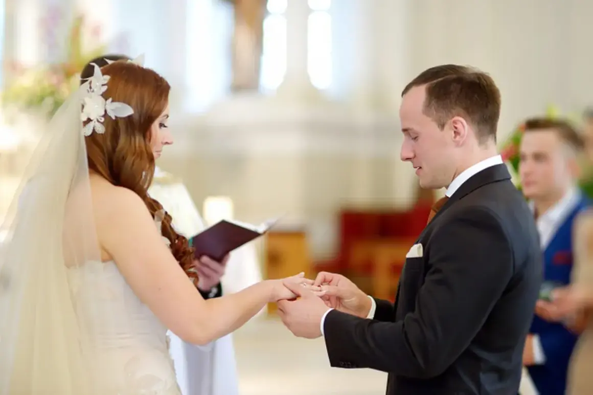 Le marié passe la bague à la mariée lors de leur mariage à l'église.