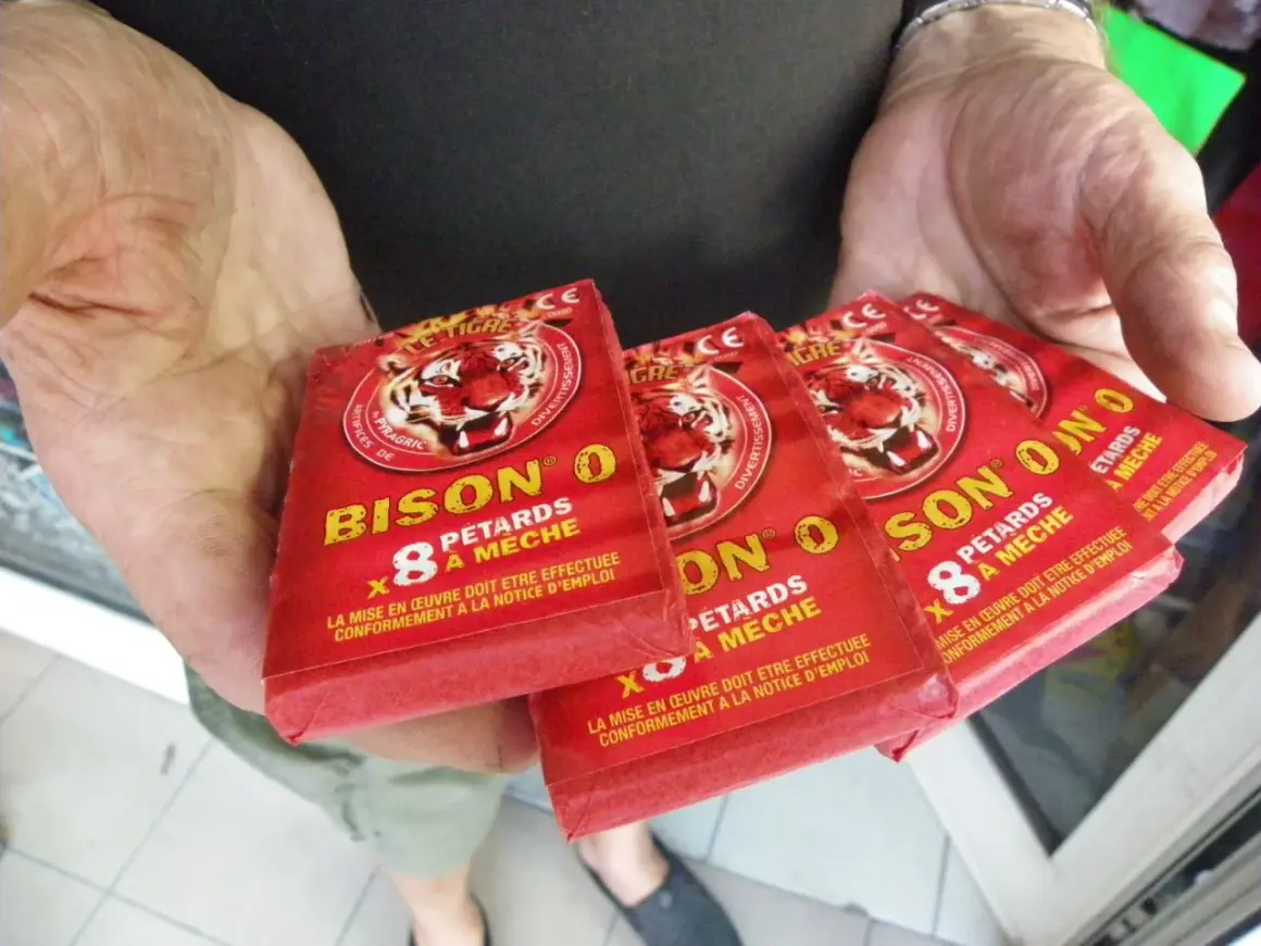 Des pétards "Bison O" sont tenus dans des mains. La question est : a-t-on le droit de faire péter des pétards ?