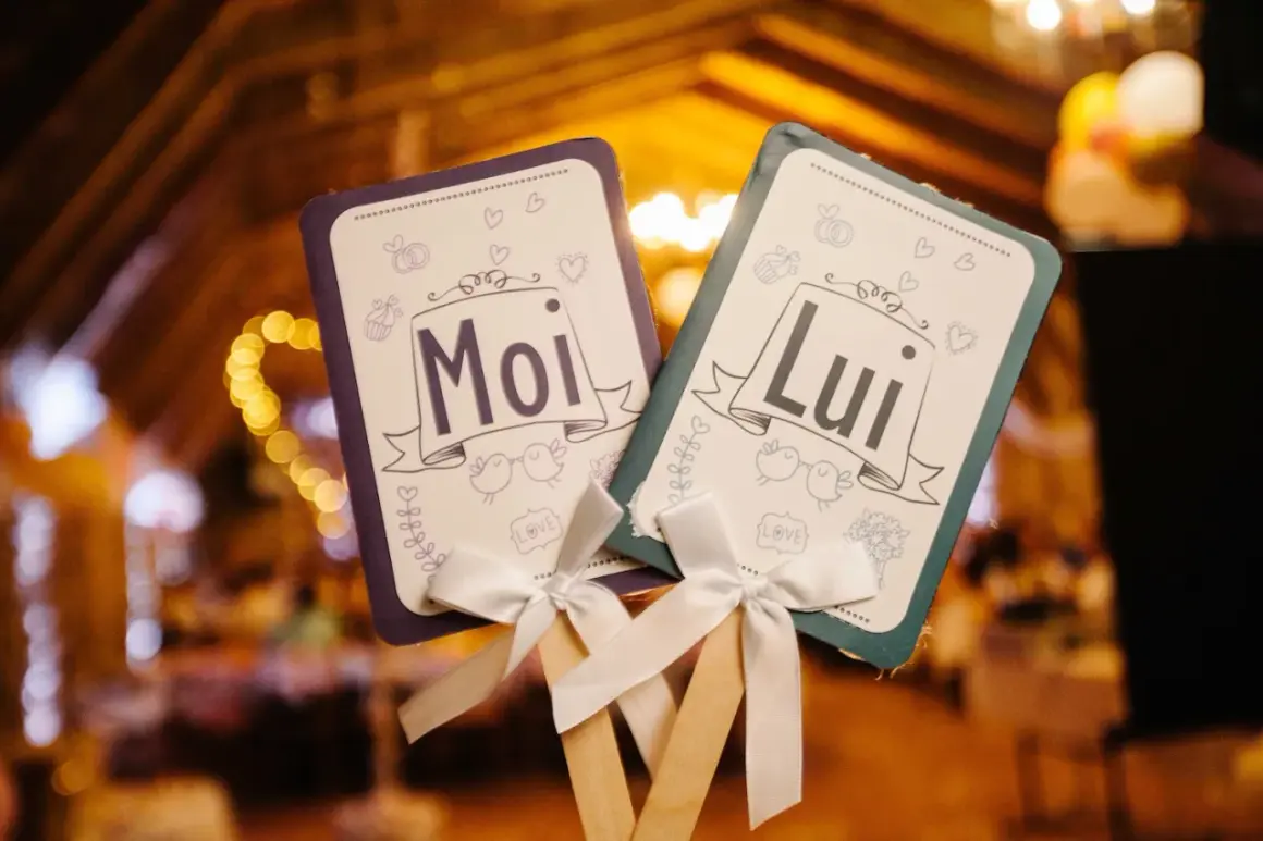 Deux pancartes "Moi" et "Lui" ornées de cœurs et d'oiseaux, parfaites pour le top des jeux de mariage.