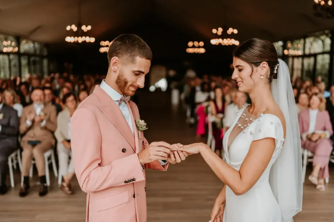 Mariage : le marié met la bague à la mariée. Comment choisir son photographe de mariage pour immortaliser ce moment ?