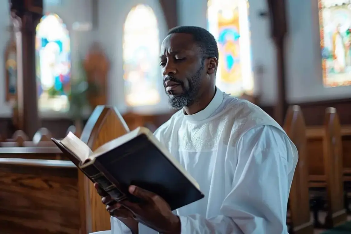 Un homme en robe blanche lit un livre dans une église, peut-être en se renseignant sur les conditions du baptême catholique.