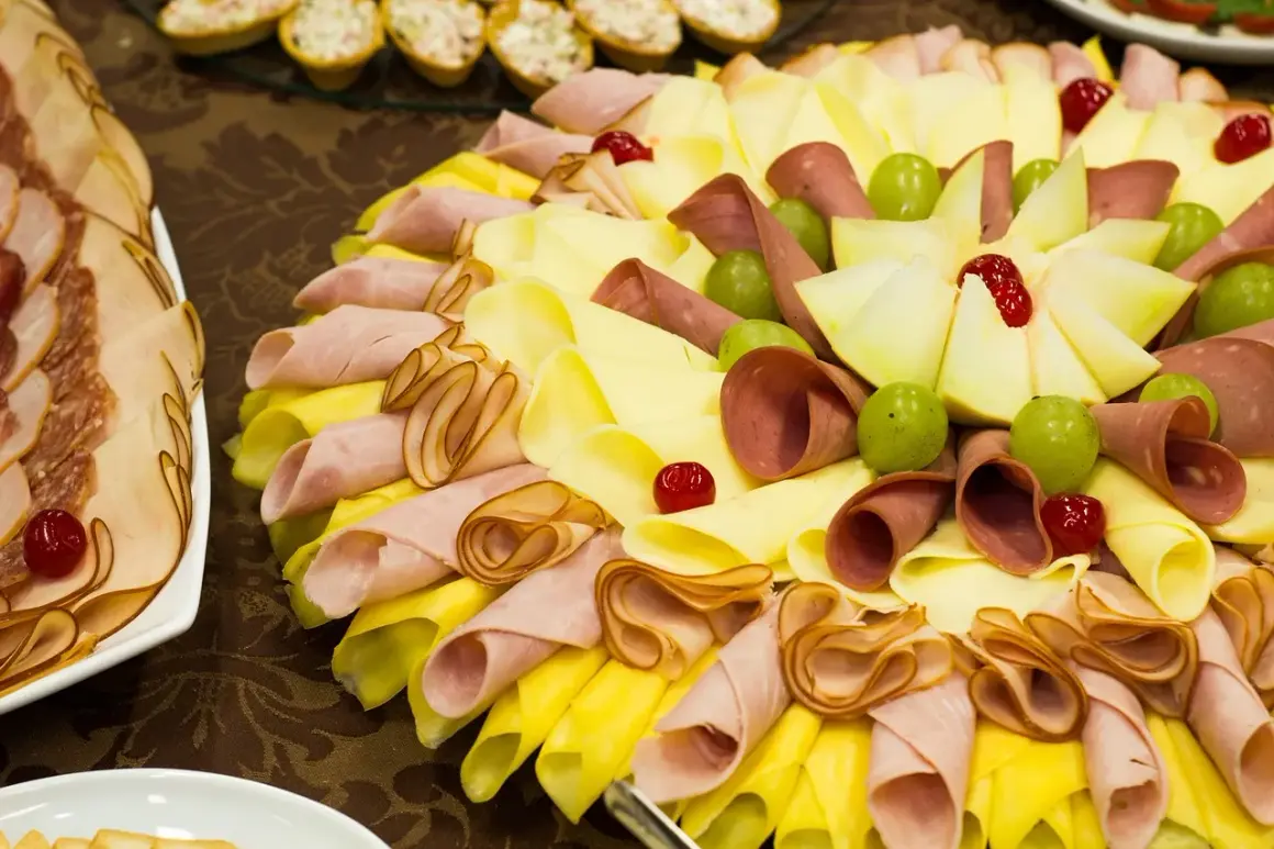 Plateau de charcuterie et fromage pour un repas baptême 30 personnes. Joliment décoré avec des fruits et des cerises confites.