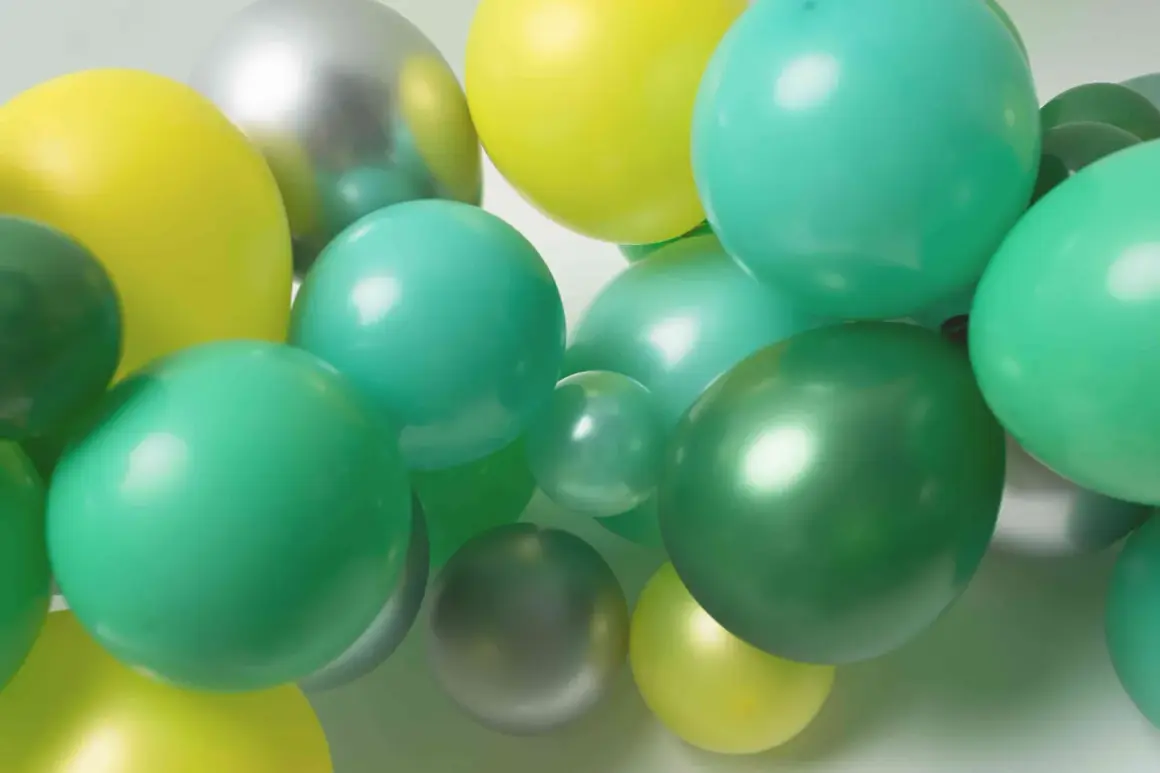Grappe de ballons verts, jaunes et argentés. Idéal pour apprendre comment attacher des ballons en grappe pour une décoration festive.