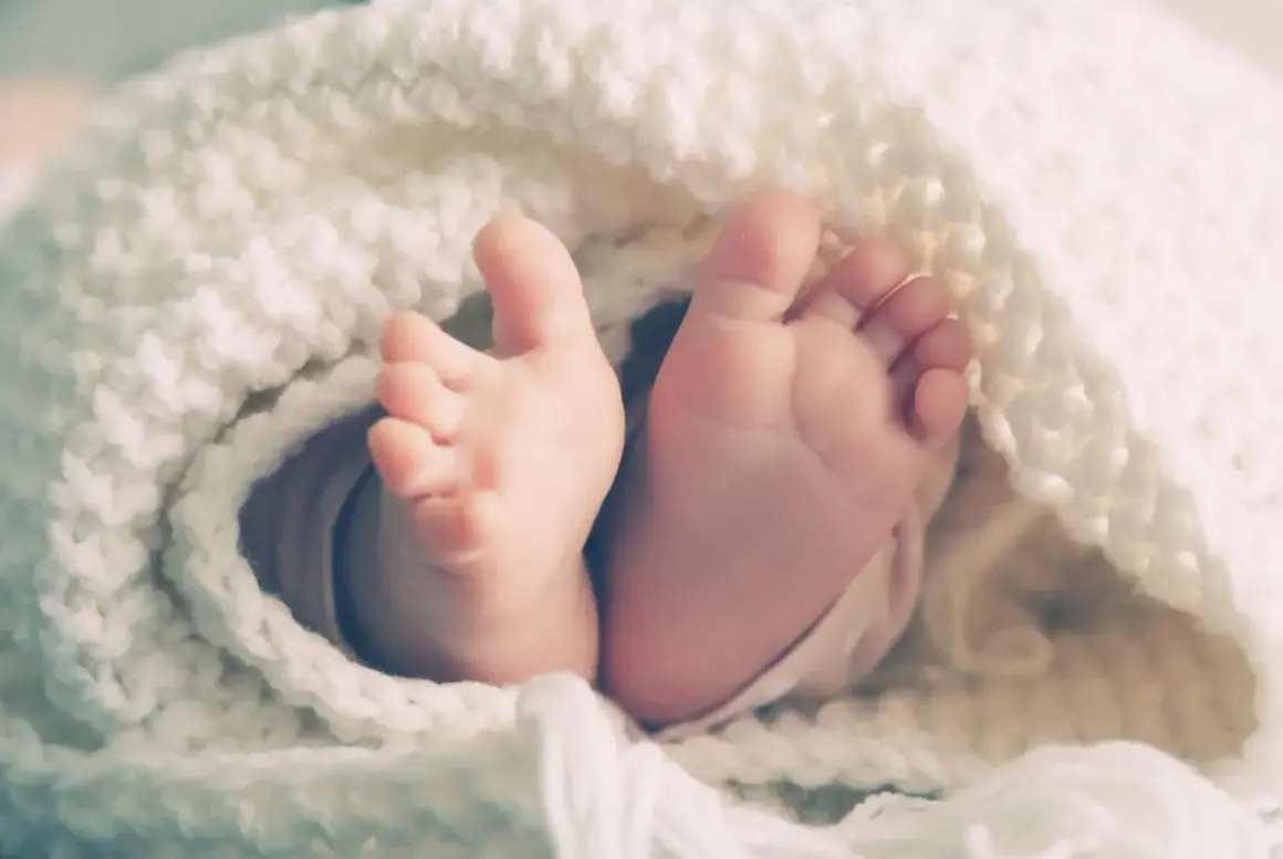 Les petits pieds d'un bébé, enveloppés dans une couverture douce, symbolisant le rôle de parrain/marraine après le décès des parents.