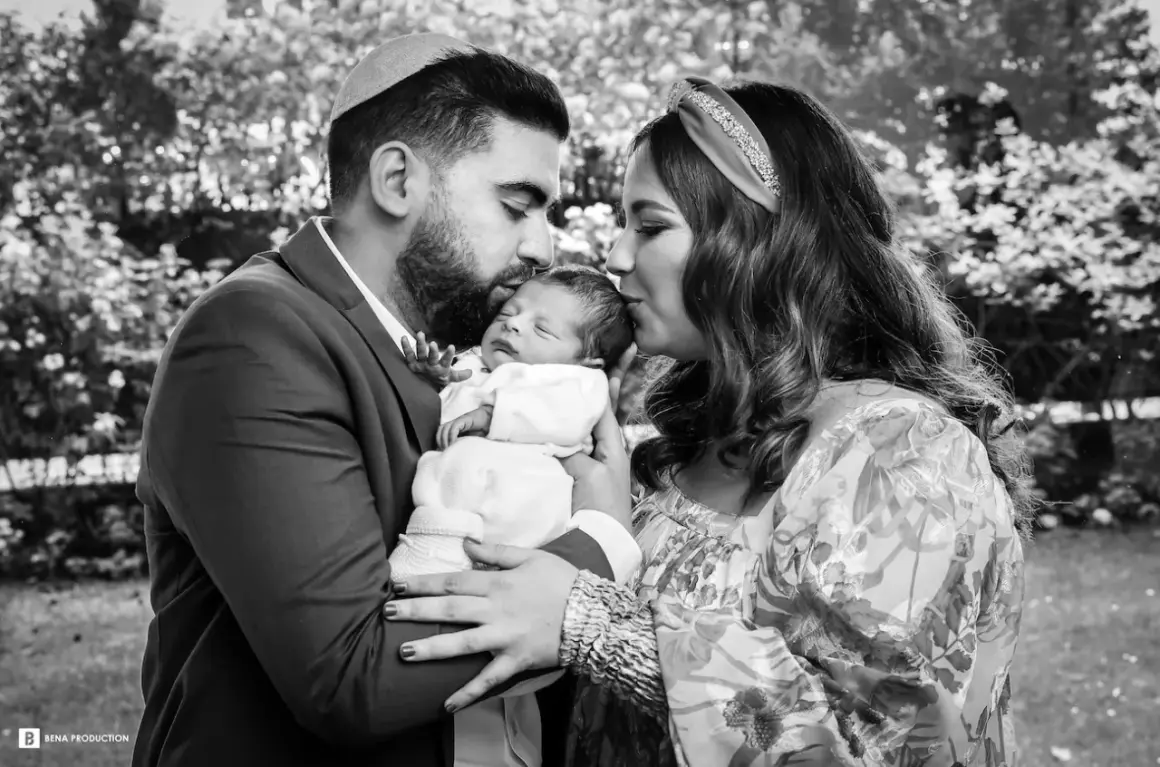 Un couple juif célèbre la circoncision de leur bébé, entourés d'amour et de tendresse.