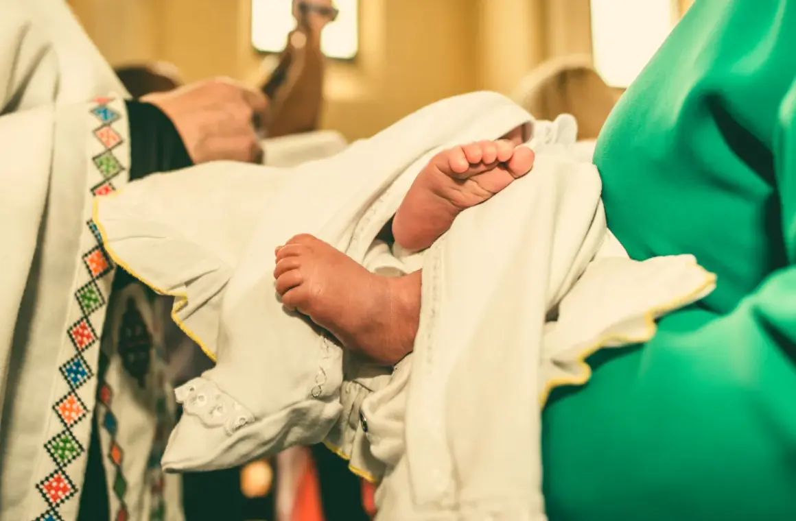 Les petits pieds d'un bébé enveloppé dans un linge blanc lors d'un baptême protestant.