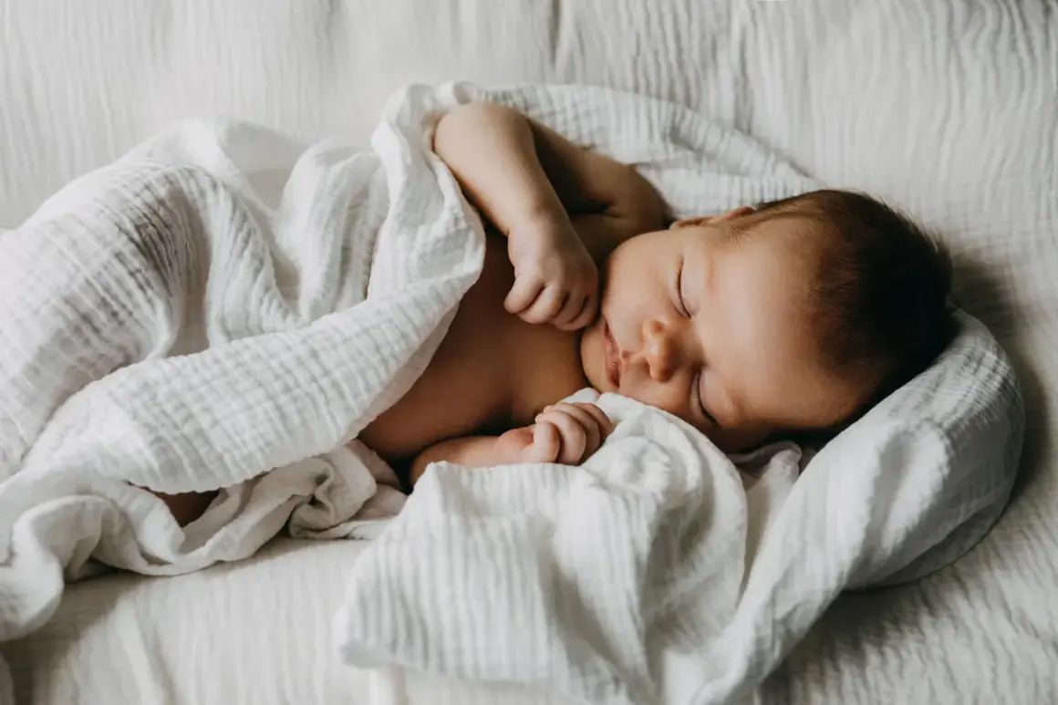 Un doux bébé endormi, parfait pour un texte félicitations naissance garçon. Un petit trésor emmailloté dans une couverture blanche.