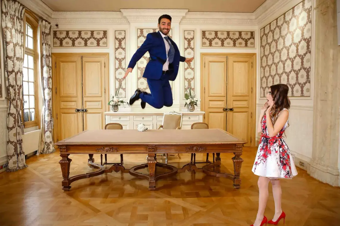 Un marié saute de joie dans la salle de la mairie, sa future épouse le regarde avec surprise. Le dossier mariage mairie est prêt !