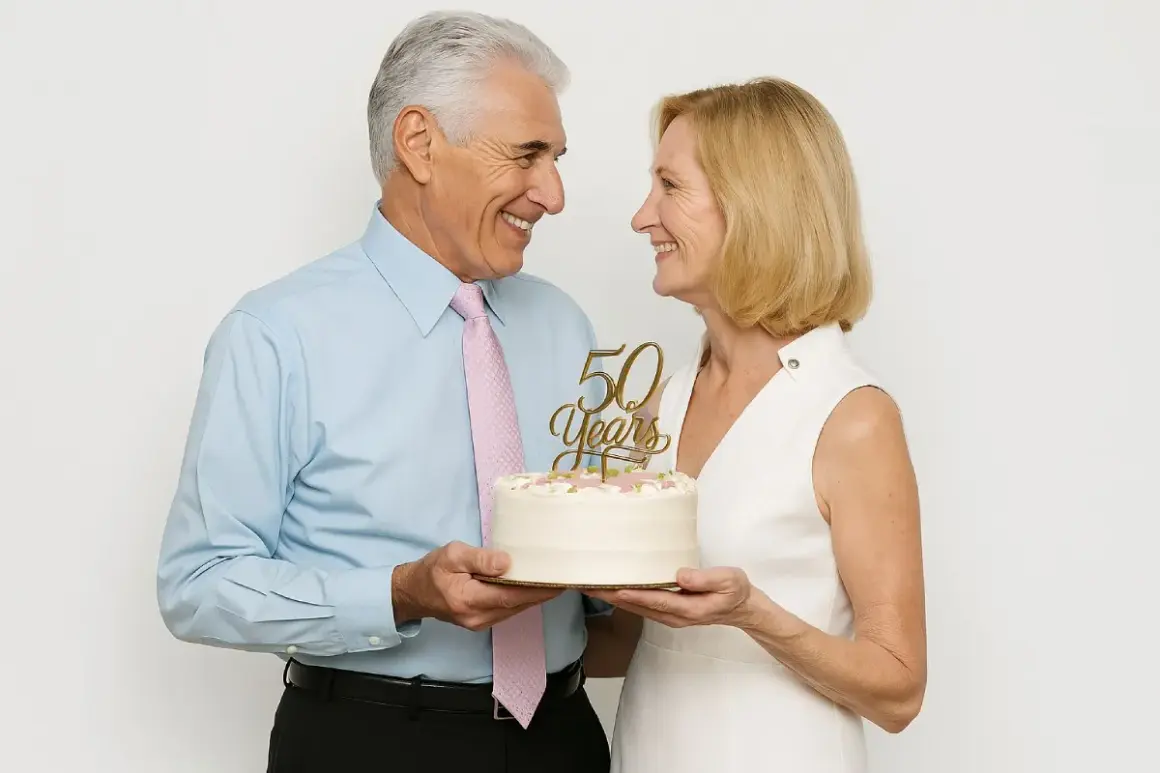 Un couple souriant célèbre son anniversaire de mariage avec un gâteau orné de "50 Years".