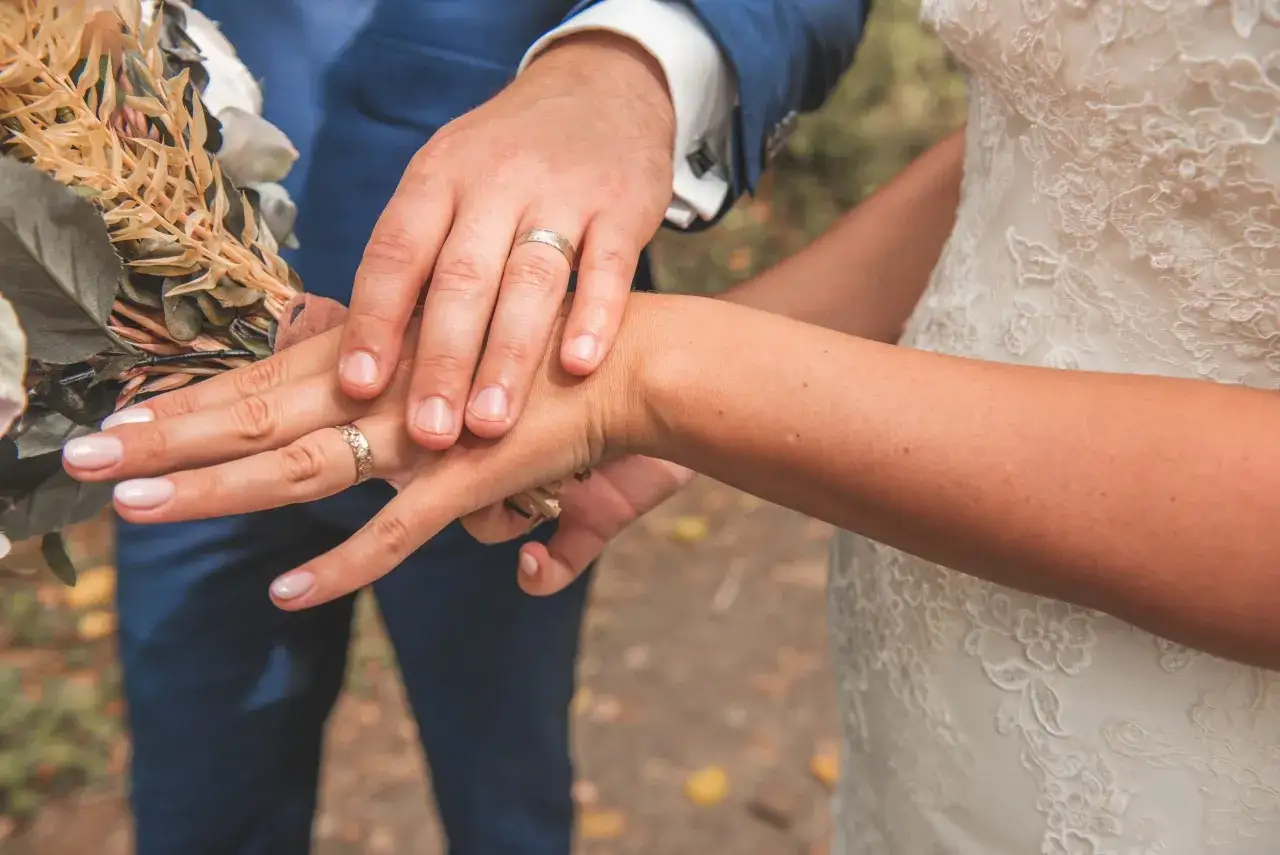 Mains jointes, alliances étincelantes, bouquet de mariée. Un instant figé, parmi les plus belles demandes en mariage.