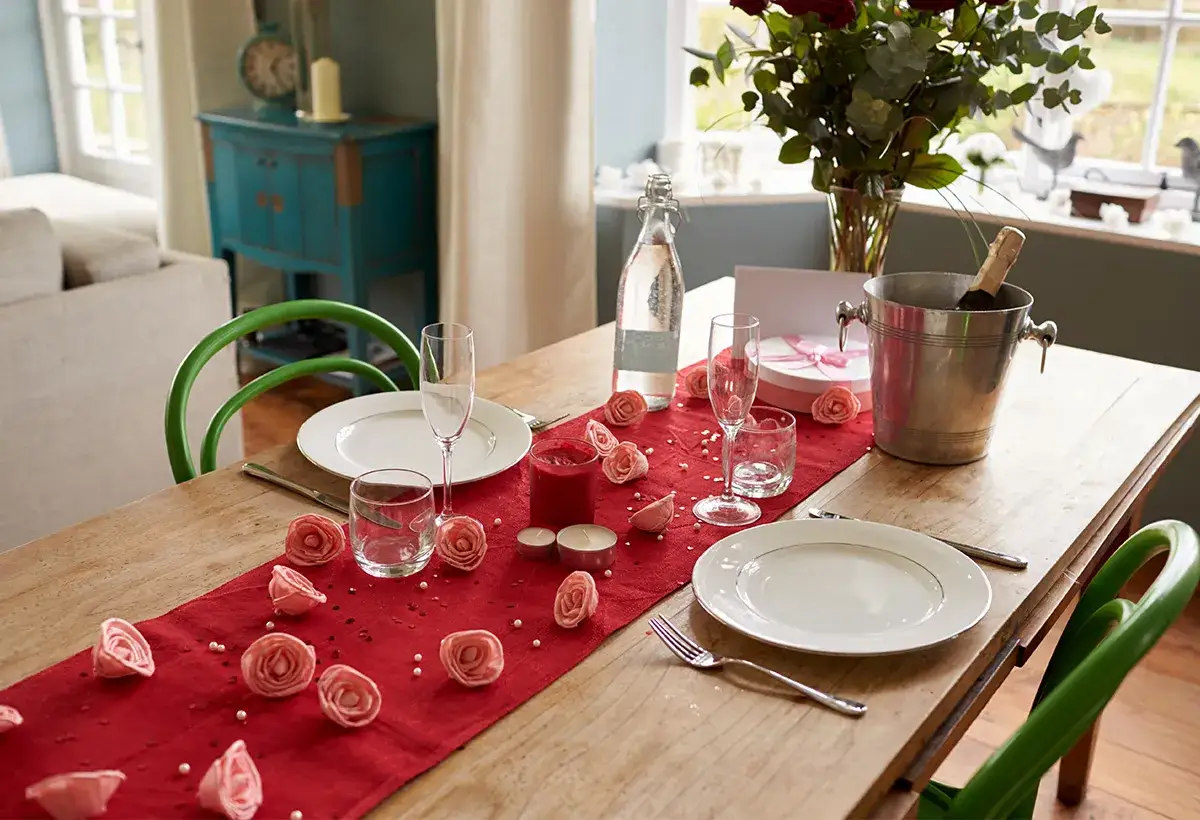 Table dress&eacute;e pour une journ&eacute;e Saint-Valentin romantique avec des roses, des bougies et du champagne.