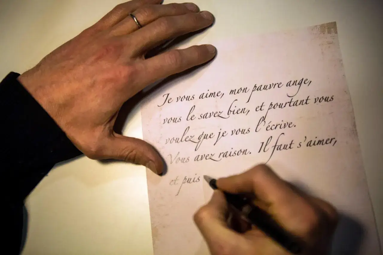 Une main écrit une lettre d'intention mariage. Le texte manuscrit exprime des sentiments profonds et une décision importante.