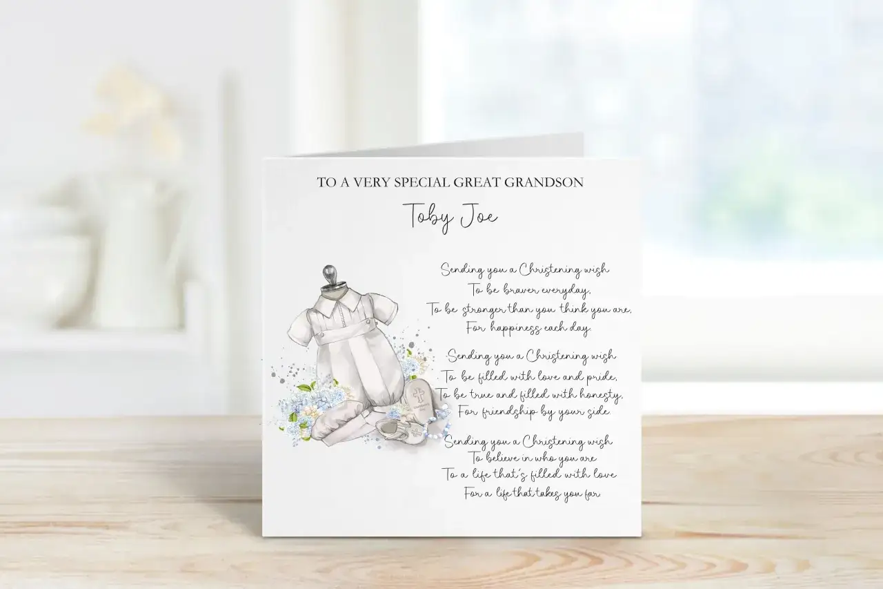 Carte de baptême pour Toby Joe, avec une tenue de bébé et des fleurs bleues. Un beau message de baptême pour un petit-fils.