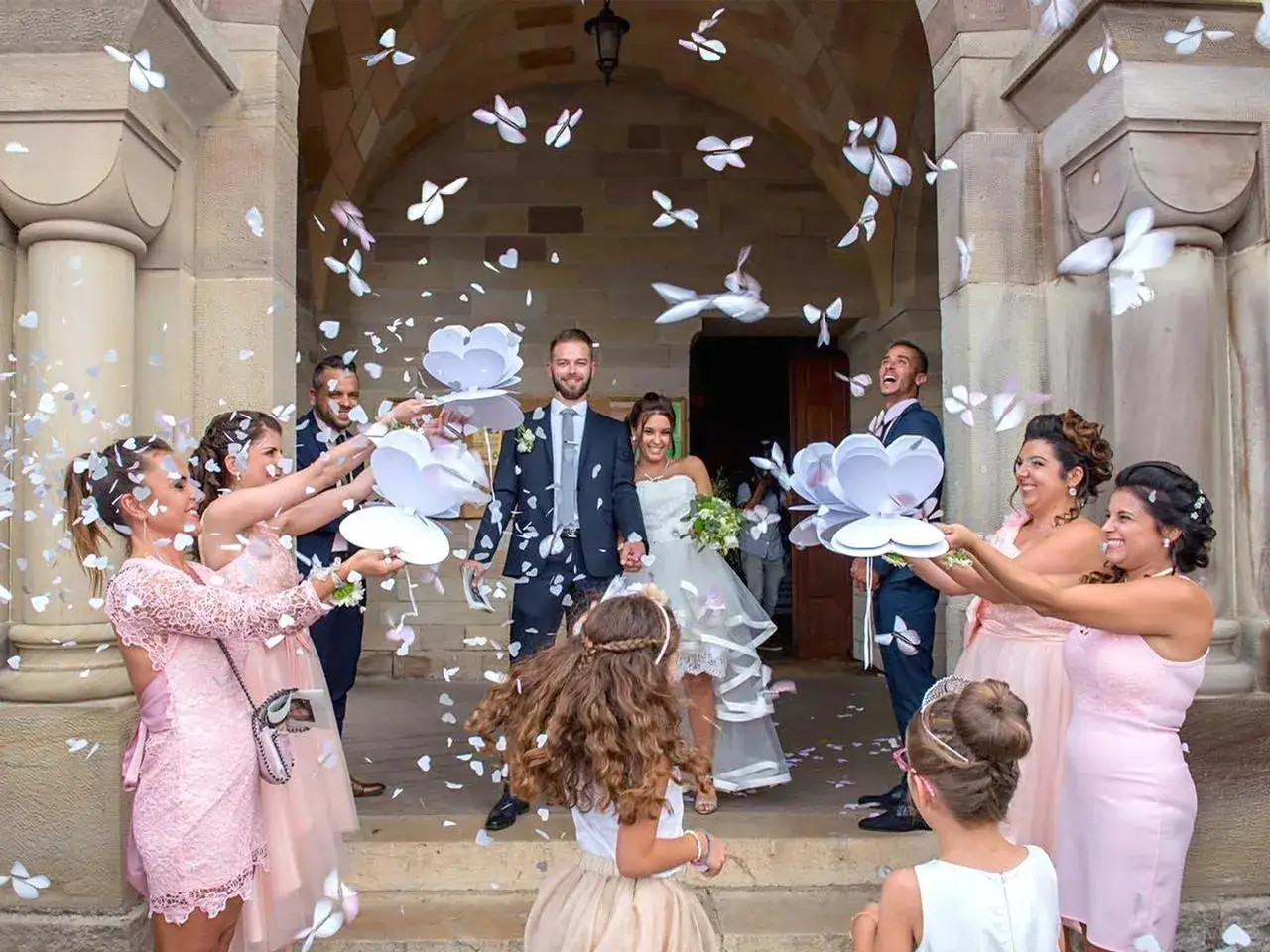 Mariage joyeux : confettis en forme de papillons pleuvent sur les mari&eacute;s &agrave; la sortie de la mairie.