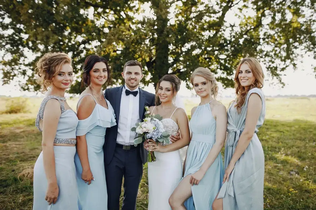 Mariée et son cortège, parfaits pour savoir comment s'habiller pour un mariage. Les demoiselles d'honneur portent des robes bleues pastel.