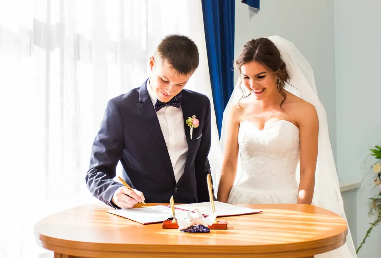 Mariage civil : le marié signe les documents, la mariée rayonne. Beaux textes pour un mariage civil.