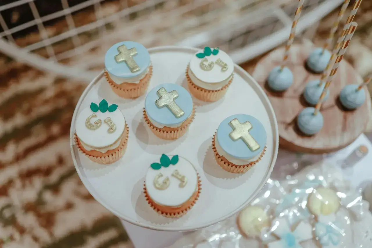 Délicieux cupcakes décorés de croix dorées et de lettres pour un repas baptême 30 personnes.