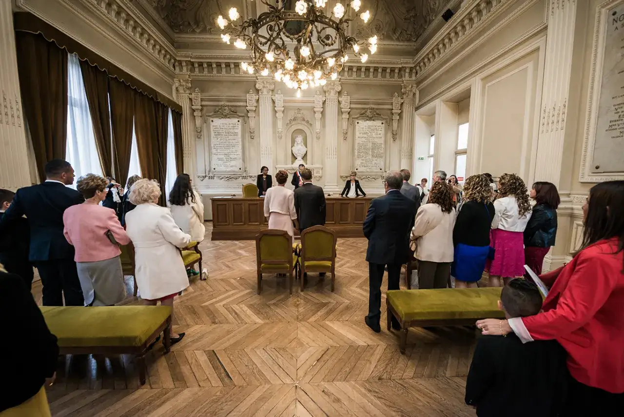 Cérémonie de mariage dans une salle solennelle. Les invités, habillés de leurs plus beaux atours, assistent à ce jour du mariage.