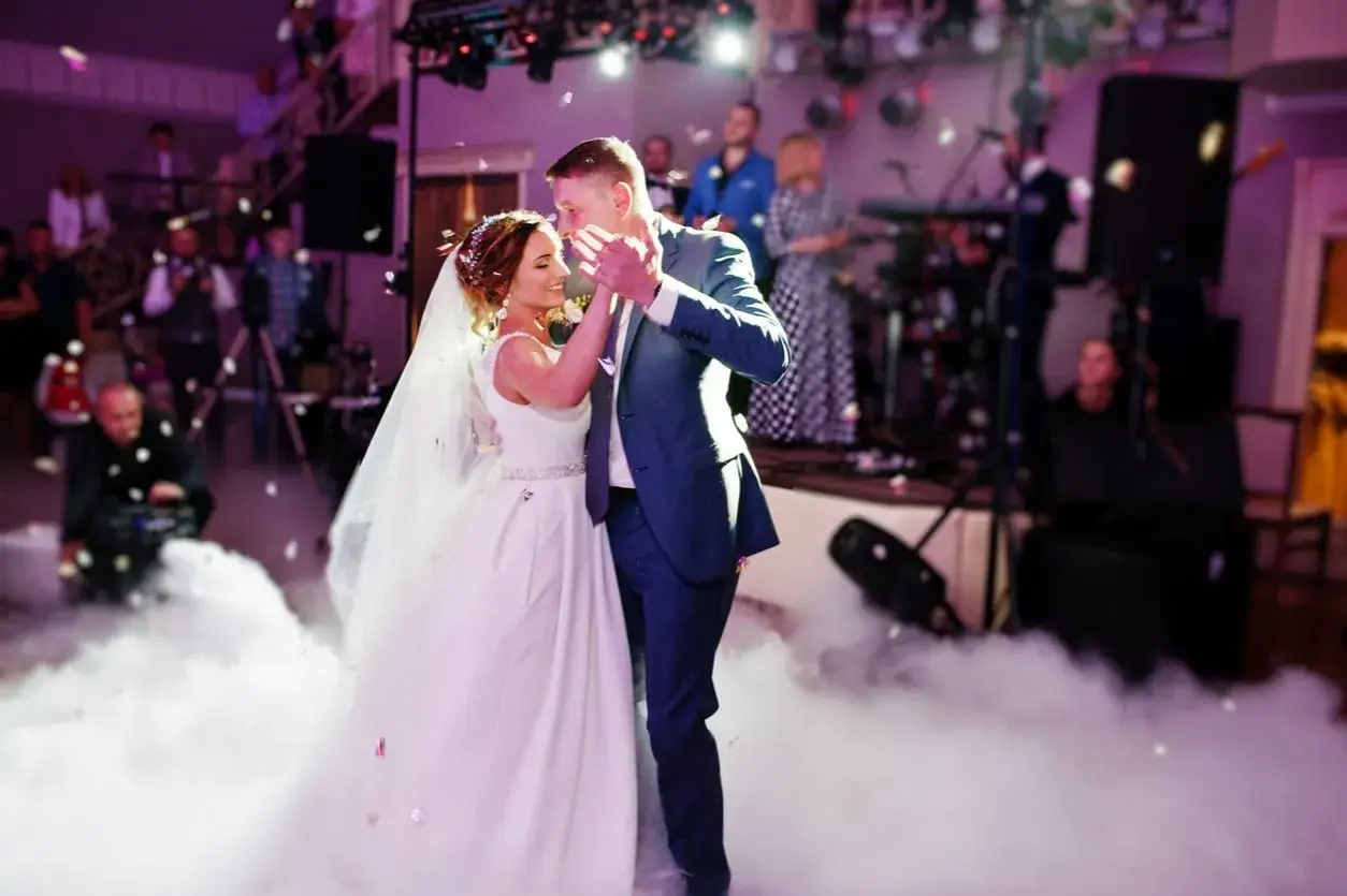 Un couple danse sur une chanson d'ouverture de bal, entouré de fumée et de confettis.