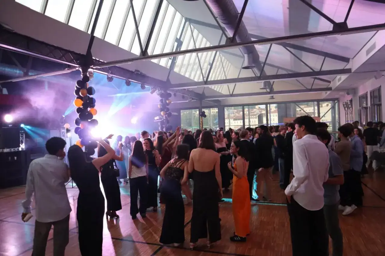 Une soir&eacute;e bal anim&eacute;e avec des jeunes dansant sous des lumi&egrave;res vives et des ballons.