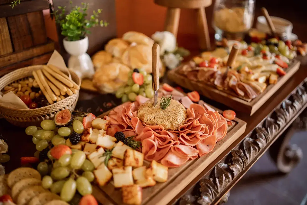 Plateau repas communion pour 20 personnes : charcuterie, fromages, fruits frais, pains et crackers. Une belle idée pour un buffet festif.
