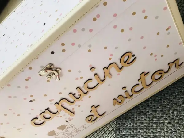 Boîte souvenir mariage personnalisée avec les prénoms "Capucine et Victor" en lettres dorées sur fond à pois.