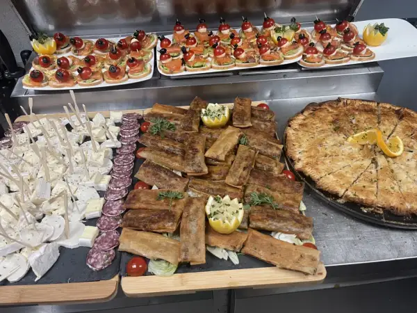 Un buffet départ retraite festif : mini-brochettes, roulés croustillants, fromages, charcuterie et une grande tarte salée.