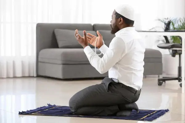 Homme en prière, tenant un chapelet, une invocation pour la circoncision dans l'islam.
