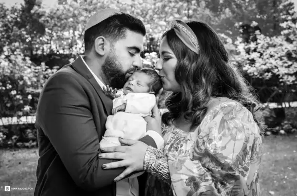 Un couple juif célèbre la circoncision de leur bébé, entourés d'amour et de tendresse.