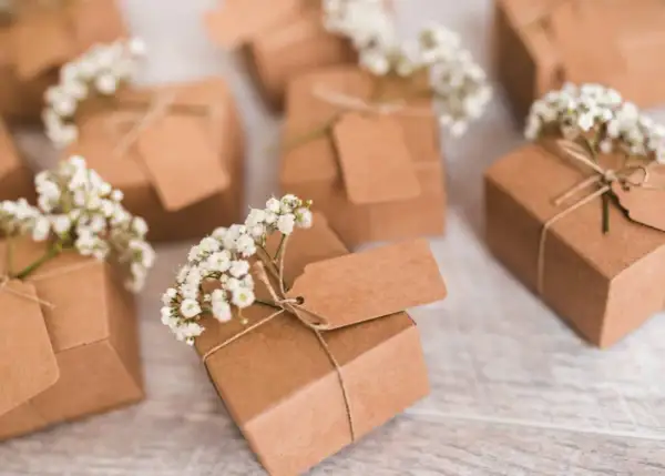 Petits pochons dragées à faire soi même, décorés de gypsophile et d'étiquettes kraft. Parfaits pour une touche personnalisée.