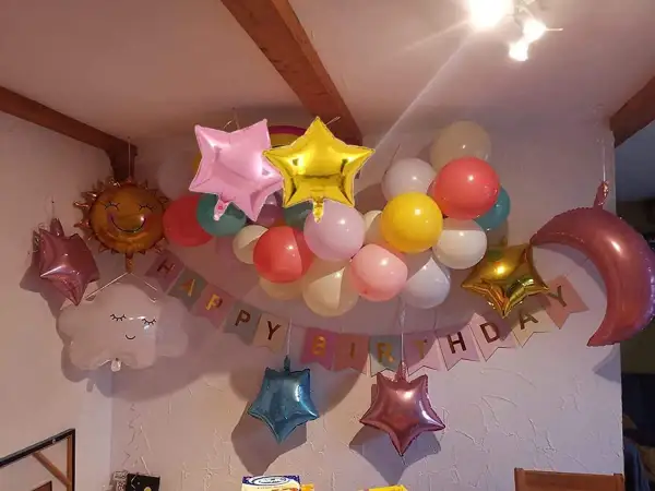 Ballons en étoile, lune, soleil et nuage flottent joyeusement, mais attention au danger de l'hélium pour les enfants.