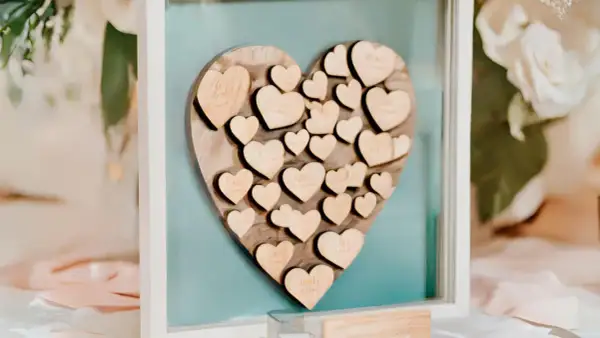 Livre d'or mariage coeur en bois, rempli de petits cœurs gravés de noms, un souvenir précieux des vœux échangés.