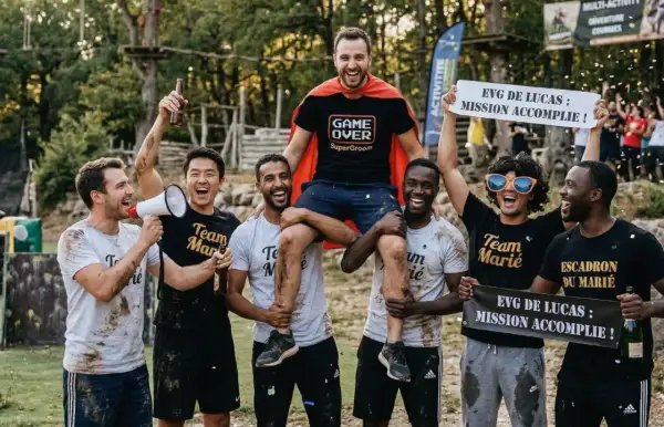 Des amis célèbrent la réussite d'un enterrement de vie de garçon. Le marié, en cape de super-héros, est porté par ses amis. Mission accomplie !